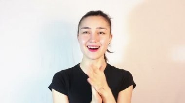 Siyah bir tişört güzel bir genç kız aktif hayranlığını ifade ve ellerini gürlemesi.