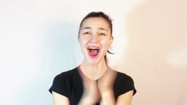 Siyah bir tişört güzel bir genç kız aktif hayranlığını ifade ve ellerini gürlemesi.