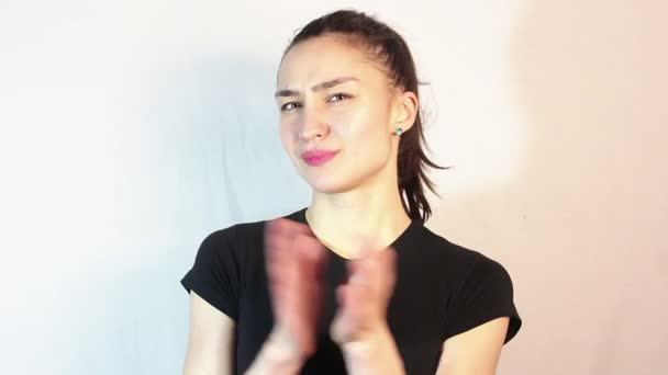 En vacker ung flicka i en svart T-shirt sarkastiskt klappar händerna. — Stockvideo