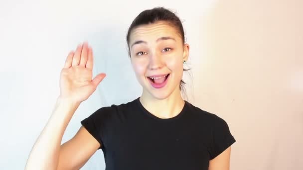 Ung attraktiv flicka ler och vinkar en hand välkomnande vänner. — Stockvideo