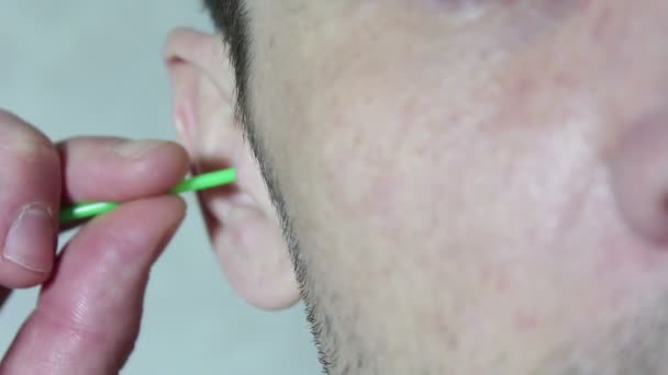 Jeune beau mec nettoie son oreille avec un bâton de coton . — Video