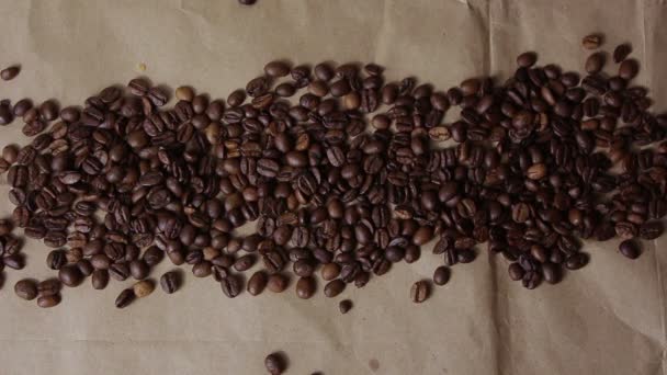 Kaffeebohnen werden weggeblasen und öffnen die auf Bastelpapier geschriebene Aufschrift Kaffee. — Stockvideo