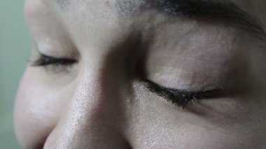 Büyük yeşil-kahverengi gözleri ile güzel bir genç kız kameraya coquettishly görünüyor.