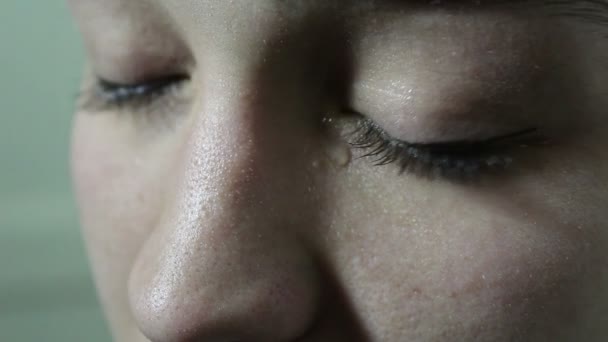 Rapariga bonita está triste e chorando. Uma lágrima rola dos olhos verdes na bochecha. Olhos close-up . — Vídeo de Stock