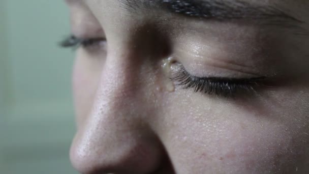 Mooi jong meisje is triest en huilen. Een scheur rolt van de groene ogen op de Wang. Ogen close-up. — Stockvideo
