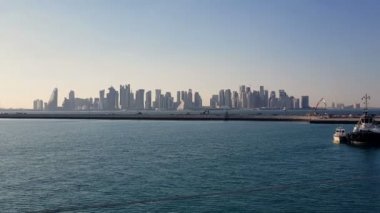 Ufukta gökdelenler ile deniz limanı ve şehir görünümü. Demirli gemilerle deniz limanı.