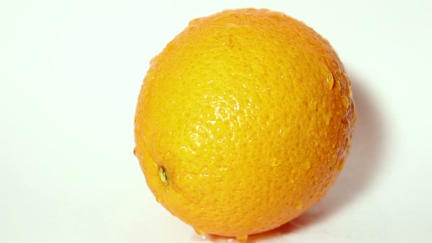 Капли воды стекают по сочному апельсину . — стоковое видео