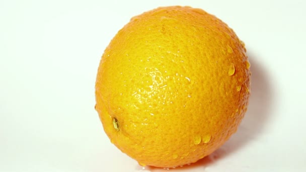 Druppels waterstromen in een sappige rijpe sinaasappel. — Stockvideo