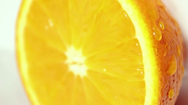 ジューシーな熟したオレンジを流れ落ちる水滴。白い背景にオレンジ. — ストック動画