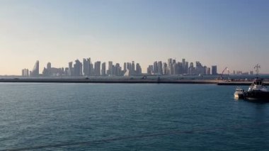 Ufukta gökdelenler ile deniz limanı ve şehir görünümü. Demirli gemilerle deniz limanı.