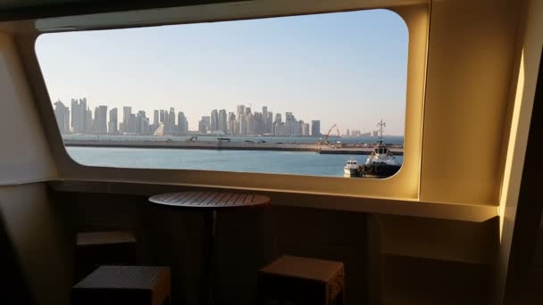 Uitzicht op de Oceaan en de stad met wolkenkrabbers aan de horizon vanuit de cabine van een cruiseschip. Uitzicht op de stad vanaf het dek van het schip. Wolkenkrabbers tegen de blauwe lucht. — Stockvideo