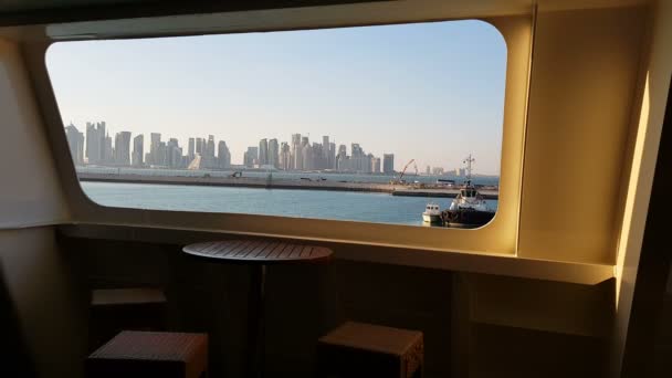 Uitzicht op de Oceaan en de stad met wolkenkrabbers aan de horizon vanuit de cabine van een cruiseschip. Uitzicht op de stad vanaf het dek van het schip. Wolkenkrabbers tegen de blauwe lucht. — Stockvideo