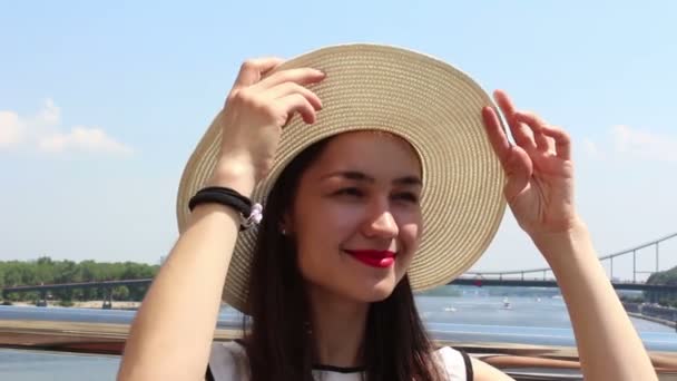 Retrato de cerca de una hermosa joven con un sombrero blanco. Joven chica atractiva en un sombrero blanco, eleva su mirada al cielo y entrecerran los ojos del sol . — Vídeos de Stock