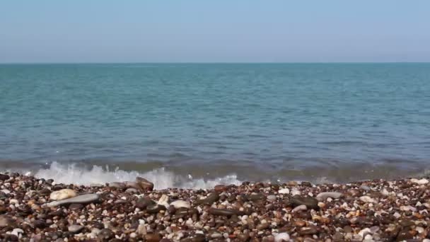 Θέα της θάλασσας και της βραχώδης ακτής, με θαλασσινή βότσαλα. Θάλασσα με καταγάλανα νερά. Θαλάσσιο σέρφινγκ στη βραχώδη ακτή. — Αρχείο Βίντεο