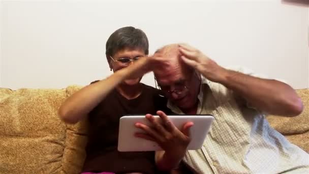Mulher adulta atraente e homem adulto fazer uma chamada de vídeo com sua família em um tablet pc . — Vídeo de Stock
