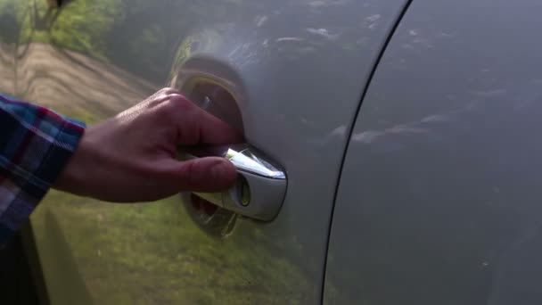 Een jong meisje opent de deur van haar auto. Close-up handen van een jong meisje open de auto deur. — Stockvideo