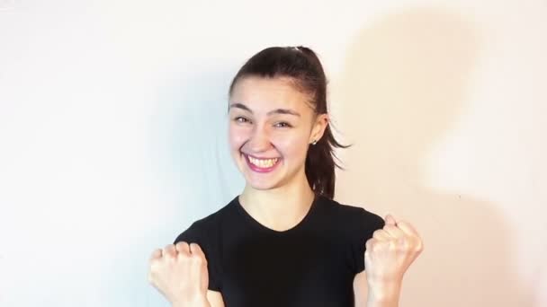 Een jong mooi meisje in een goed humeur glimlacht, zegt ja en maakt een handgebaar. — Stockvideo