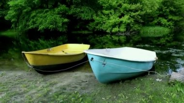 Nehirdeki tekneler. Orman manzarası ve nehir kıyısı, demirli teknelerle.