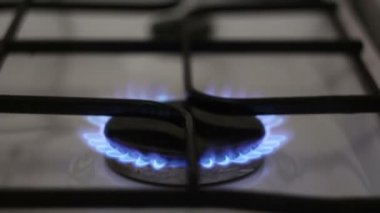 Yanan bir gaz ocağı. Mutfak gaz ocağı maviyle yanıyor. Mutfakta bir gaz ocağı yanıyor..