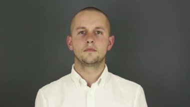 Komik, yakışıklı bir adam anlaşmazlığını ifade eder ve kollarını kavuşturarak yasaklama jesti yapar. Genç bir adamın portresi, tasvip etmediğini ifade ediyor ve yüzünü çapraz kollarla kapatıyor. Gri arkaplanda bir portre.