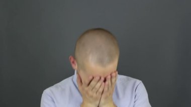 Komik, güzel bir adam, hapşırıyor ve eliyle ağzını kapatıyor. Genç bir adamın portresi, soğuk algınlığından şiddetle hapşırır ve eliyle ağzını kapatır..