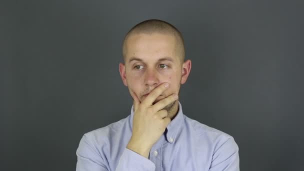A funny, handsome guy is actively thinking about a problem and suddenly the right decision comes to him. A portrait of a young guy, he actively reflects on a solution to the problem and the right — Stock Video