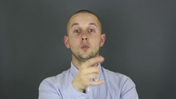 Un gars drôle et mignon demande un rappel et fait un geste de la main. Portrait d'un jeune homme, il fait un geste de main à côté de son oreille demandant un rappel. — Video