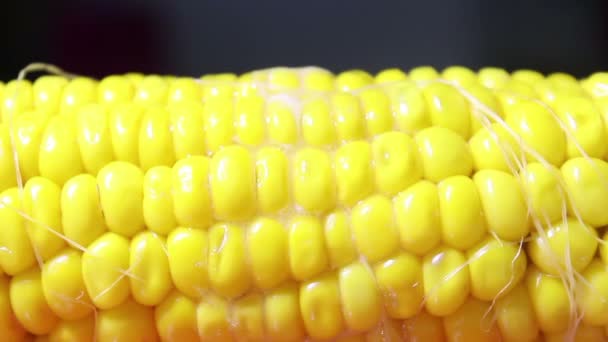 A piece of butter melts and drains over juicy hot corn. Juicy hot corn close-up. — Stock Video