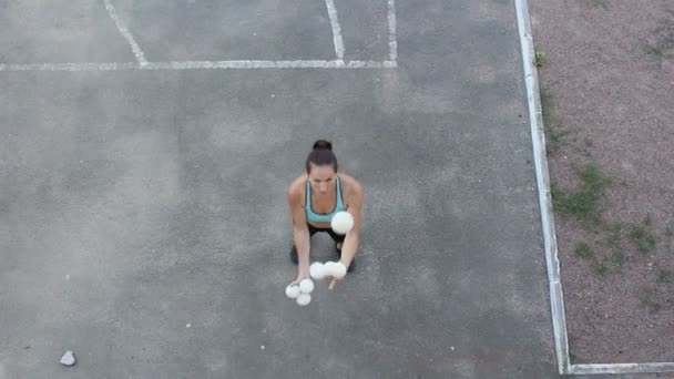 Profesionální žonglér s bílými koulemi. Atraktivní dívka žonglér trénuje její žonglérské dovednosti. Profesionální cirkusová herečka žongluje s bílými koulemi na ulici. — Stock video