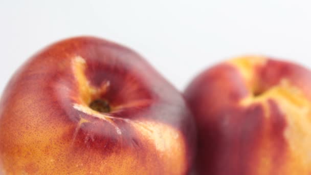 Buah persik segar di piring putih. Close-up Peaches organik segar nectarine pada piring putih. — Stok Video