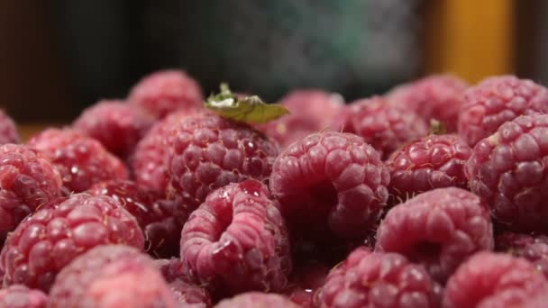 Les framboises juteuses mûres reposent sur une assiette. Gros plan sur les framboises biologiques mûres. — Video