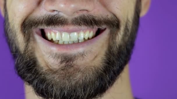 Knappe man met een baard die naar de camera kijkt en glimlacht. Close-up van een lachende jonge man met baard. — Stockvideo