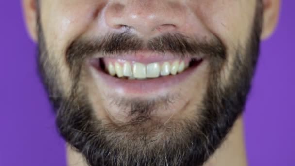 Hezký vousatý muž, dívající se do kamery a usmívající se. Detailní záběr usmívajícího se mladého vousatého chlapa. — Stock video