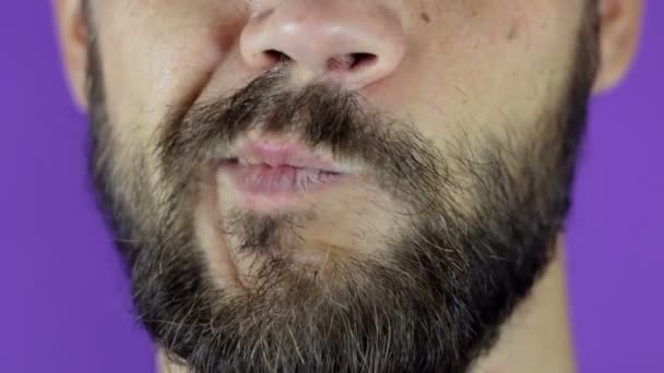 Knappe man met een baard die naar de camera kijkt en zijn twijfel laat zien. Close-up van een jonge man met een baard met twijfel op zijn gezicht. — Stockvideo