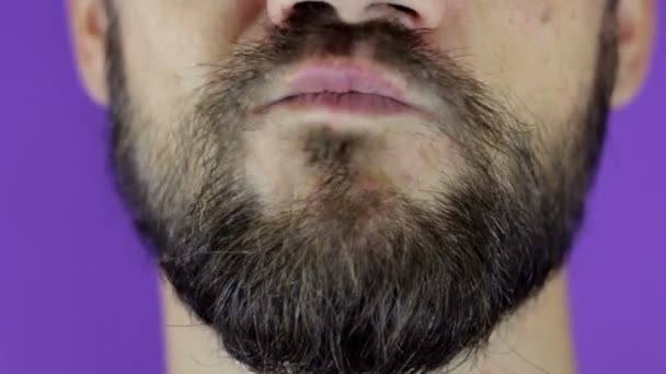 Knappe man met een baard die naar de camera kijkt en zijn twijfel laat zien. Close-up van een jonge man met een baard met twijfel op zijn gezicht. — Stockvideo