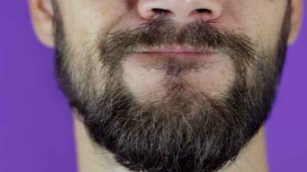 Een knappe man met een baard kijkt naar de camera en schudt zijn hoofd negatief. Close-up van een jonge man met een baard twijfel op zijn gezicht. — Stockvideo