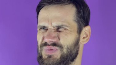 Komik, tatlı bir adam havayı kokluyor ve burnunu mavi bir mandalla kapatıyor. Yakışıklı sakallı bir adam burnunu mandalla çimdikler ki o nahoş kokuyu içine çekmesin..