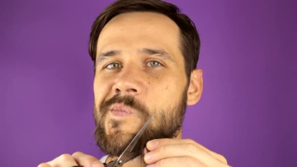 英俊的小伙子用剪刀修剪胡子 一个年轻英俊男子用剪刀剪胡子时的近视 — 图库视频影像