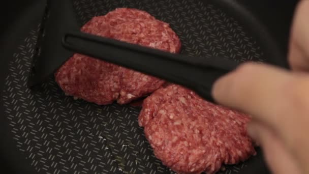 シェフは牛肉のパテをフライパンに入れます ジューシーな牛カツをフライパンで揚げたもの ハンバーガー用の肉カツを閉じる — ストック動画