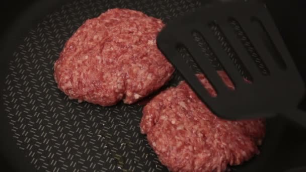 シェフは牛肉のパテをフライパンに入れます ジューシーな牛カツをフライパンで揚げたもの ハンバーガー用の肉カツを閉じる — ストック動画