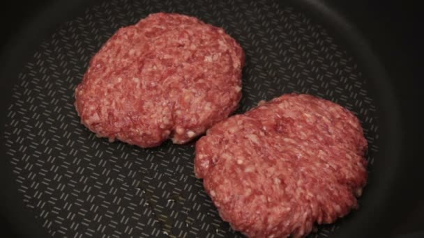 シェフは牛肉のパテをフライパンに入れます ジューシーな牛カツをフライパンで揚げたもの ハンバーガー用の肉カツを閉じる — ストック動画