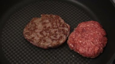 Bir şef ızgaraya köfte koyar. Tavada kızartılmış sulu bir sığır pirzolası. Biftek pirzolası ve ızgarada bir hamburger..