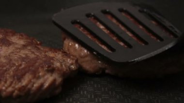 Bir şef ızgaraya köfte koyar. Tavada kızartılmış sulu bir sığır pirzolası. Izgarada burger için sığır pirzolası yakın plan. Bir şef ızgara pirzolayı ters çevirir..