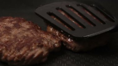 Bir şef ızgaraya köfte koyar. Tavada kızartılmış sulu bir sığır pirzolası. Izgarada burger için sığır pirzolası yakın plan. Bir şef ızgara pirzolayı ters çevirir..