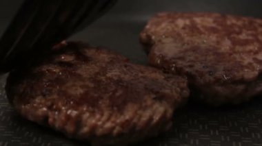 Bir şef ızgaraya köfte koyar. Tavada kızartılmış sulu bir sığır pirzolası. Izgarada burger için sığır pirzolası yakın plan. Bir şef ızgara pirzolayı ters çevirir..