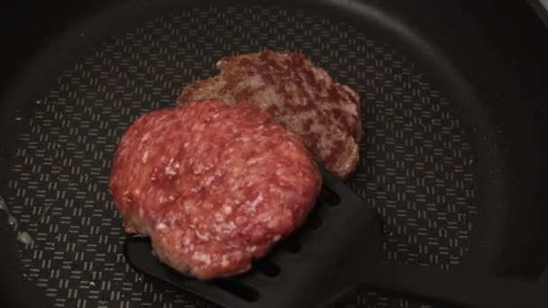 シェフは牛肉のパテをフライパンに入れます ジューシーな牛カツをフライパンで揚げたもの ハンバーガー用の肉カツを閉じる — ストック動画