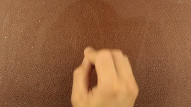En man skriver ett frågetecken i krita på en brun bakgrund. Närbild av en mans hand skriver ett frågetecken i krita på en brun svarta tavlan. — Stockvideo