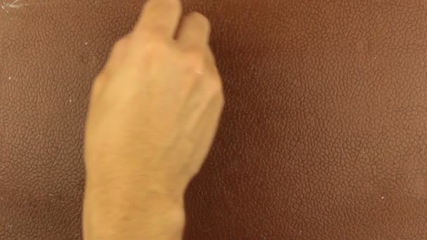 L'homme écrit le mot sexe à la craie sur un fond brun. Gros plan de la main masculine écrit le mot sexe à la craie sur un tableau noir brun. — Video