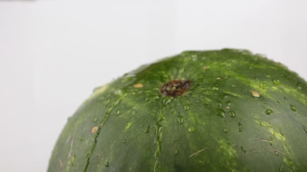 Druppels water stromen door de schil van een sappige watermeloen. Verse sappige gestreepte watermeloen close-up. — Stockvideo