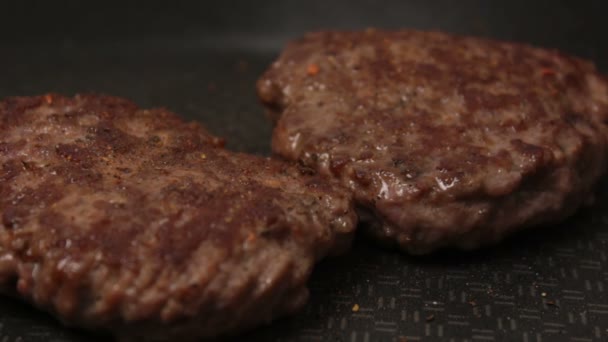 Un chef pone empanadas de carne en la parrilla. Una jugosa chuleta de ternera, frita en una sartén. Primer plano de chuleta de ternera para una hamburguesa en la parrilla. — Vídeos de Stock